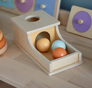 Toddler interacting with a Montessori Ball Box