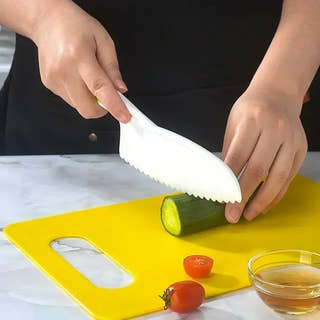 cutting vegetables with a Montessori kitchen kit.